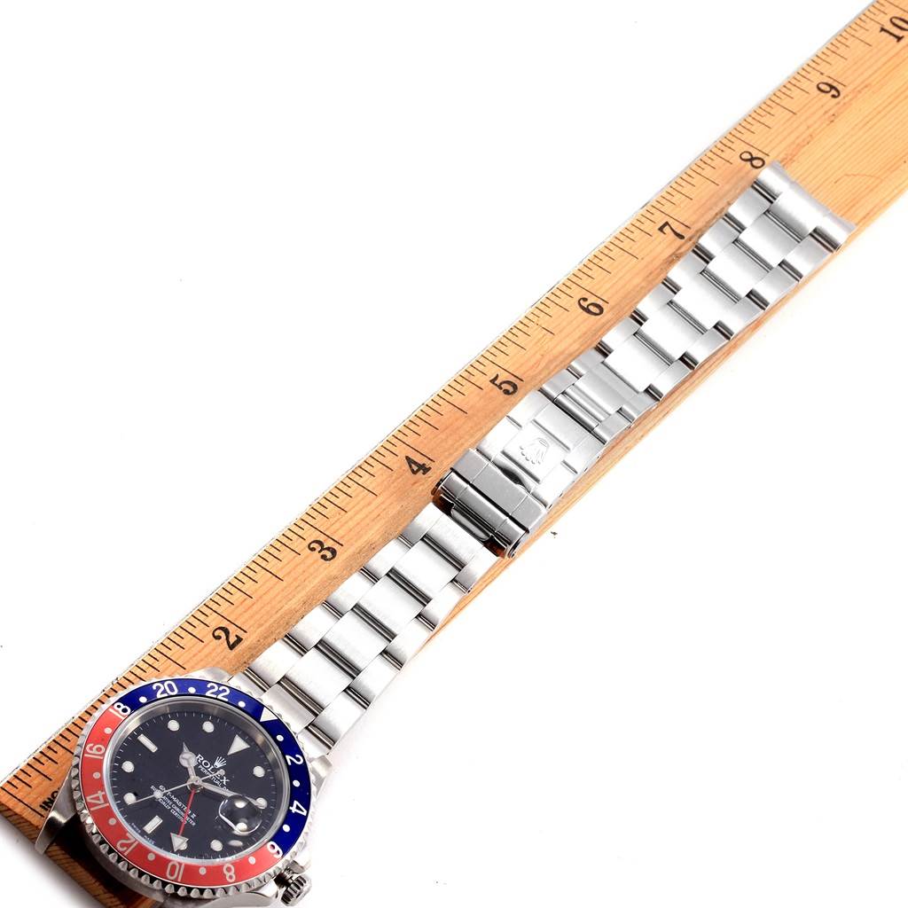 The image shows a Rolex GMT-Master 16710 Men's Stainless Steel Black Dial 16710 Men's Stainless Steel Black Dial watch laid flat against a ruler, displaying the bezel, dial, and metal bracelet.