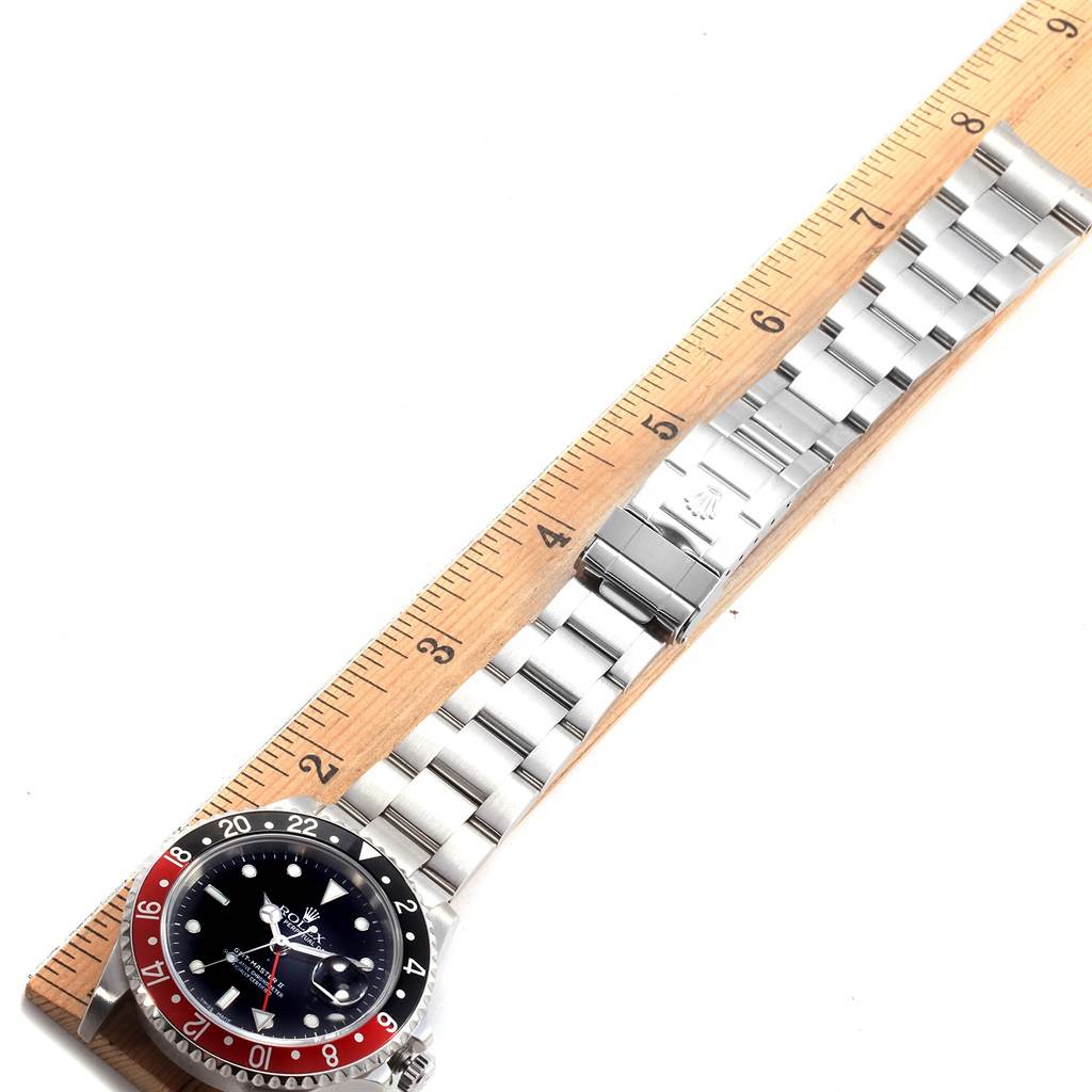 The image shows the Rolex GMT-Master 16710 Men
s Stainless Steel Black Dial 16710 Men
s Stainless Steel Black Dial watch placed against a ruler, displaying its face, bezel, case, and full bracelet.