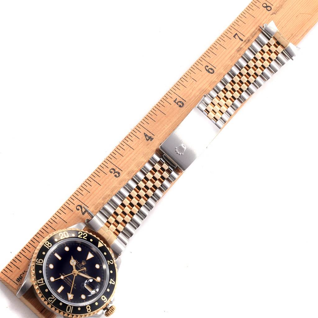 The Rolex GMT-Master 16713 Men's Stainless Steel Black Dial 16713 Men's Stainless Steel Black Dial watch is shown from above with the full bracelet extended alongside a ruler for scale.