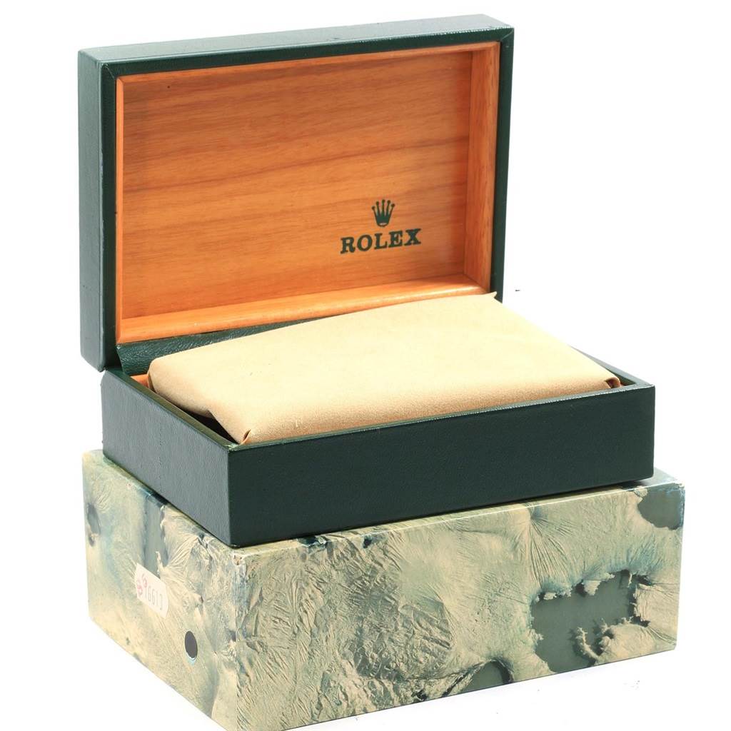 The image shows an open green Rolex watch box for the GMT-Master model, placed on a textured outer box.