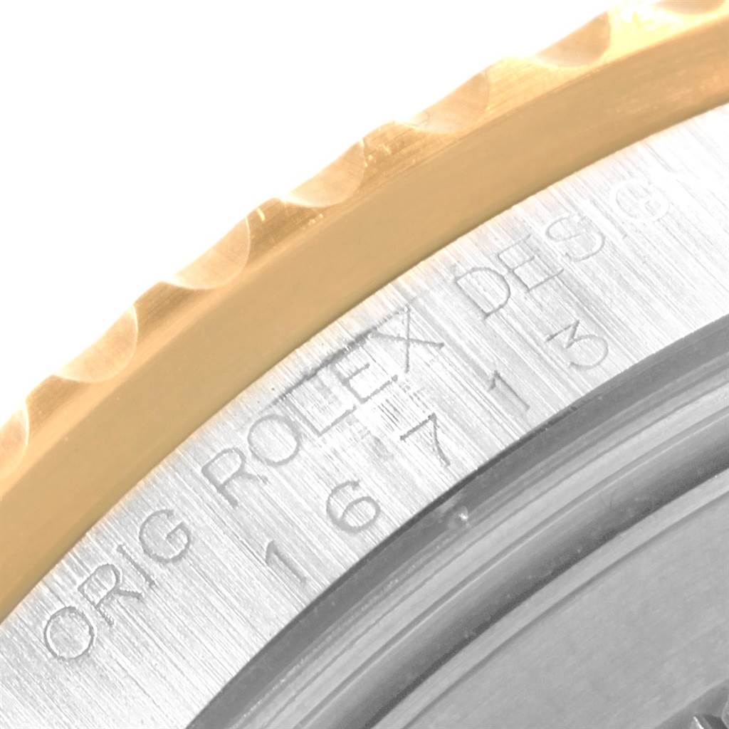 The image shows a close-up of the bezel and the engraved side of the case of the Rolex GMT-Master 16713 Men's Stainless Steel Brown Dial 16713 Men's Stainless Steel Brown Dial watch.