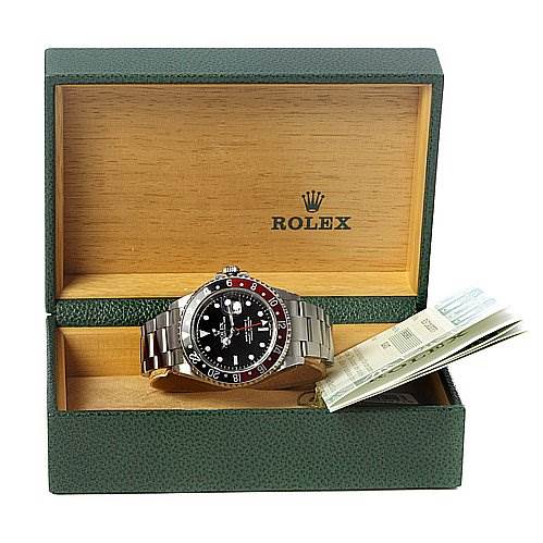 The Rolex GMT-Master 16710 Men's Stainless Steel Black Dial 16710 Men's Stainless Steel Black Dial watch is displayed at a front-facing angle inside its branded box, with accompanying documents visible.