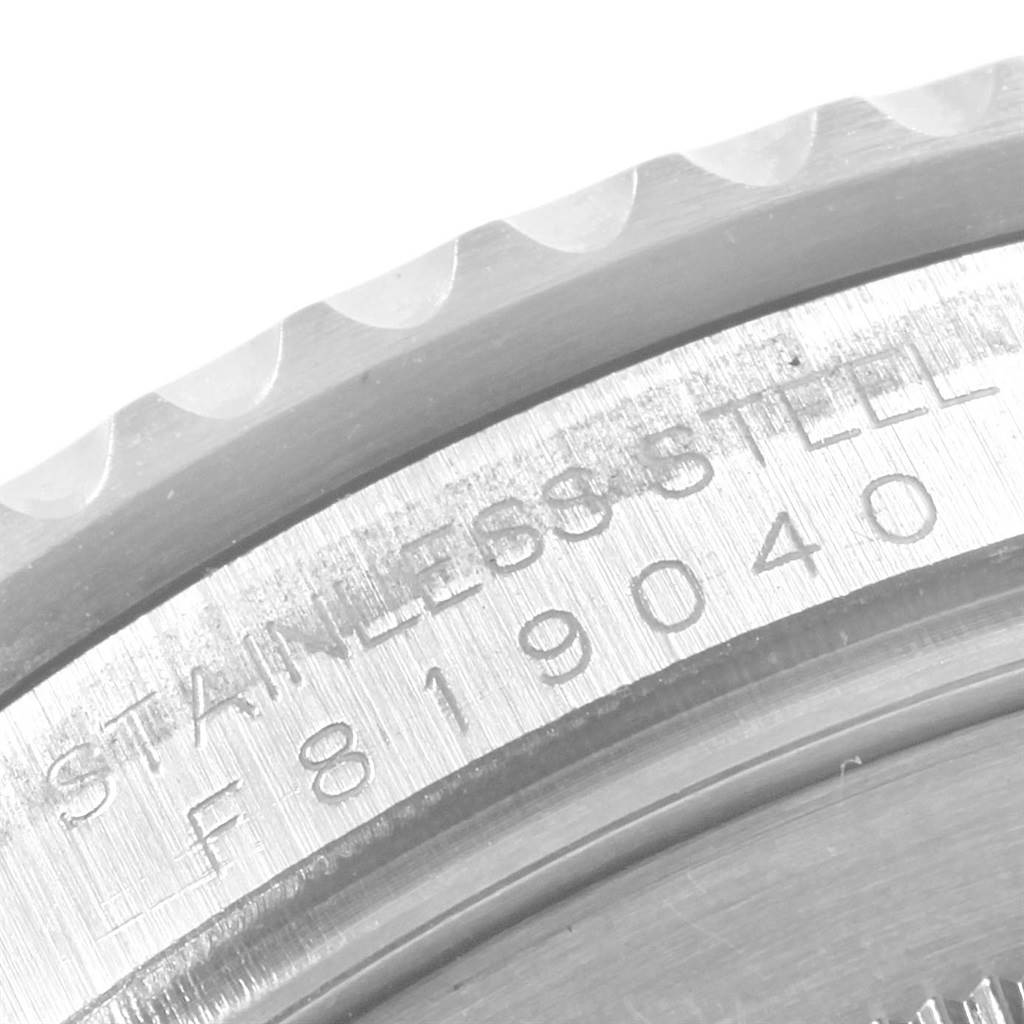 This is an angled close-up of the stainless steel case back of a Rolex GMT-Master 16710 Men's Stainless Steel Black Dial 16710 Men's Stainless Steel Black Dial watch, showing engravings and the edge of the bezel.