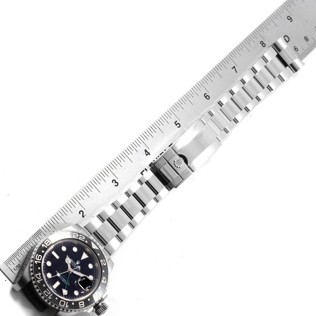 The image shows a Rolex GMT-Master 116710 Men
s Stainless Steel Black Dial 116710 Men
s Stainless Steel Black Dial watch at an angle measuring the length of its band with a ruler.