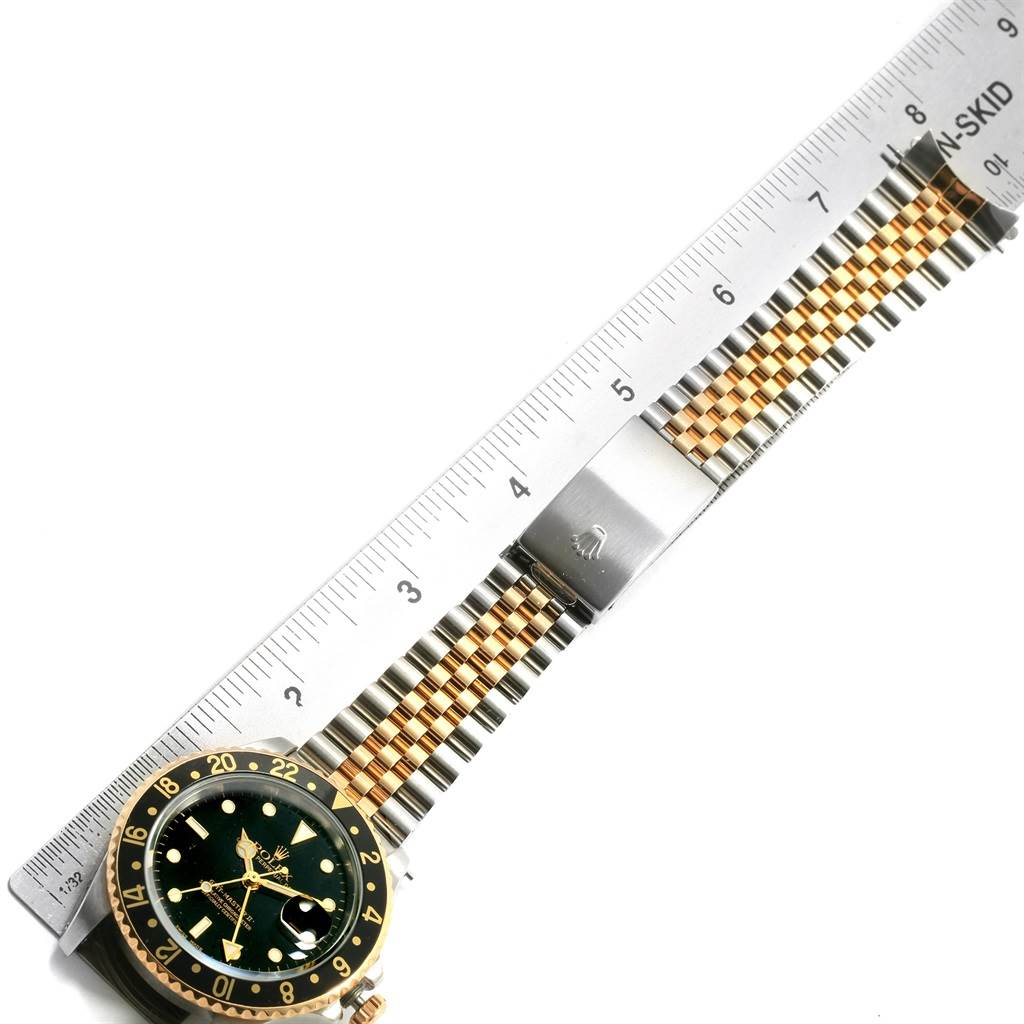 This image shows a Rolex GMT-Master 16713 Men's Stainless Steel Black Dial 16713 Men's Stainless Steel Black Dial watch laid flat with a ruler next to it, highlighting the bezel, dial, and two-tone bracelet.