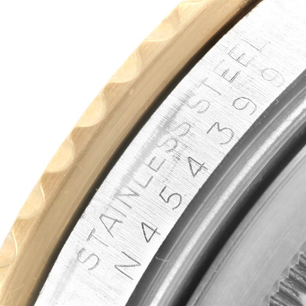 This close-up image shows the engravings on the inner bezel and part of the outer bezel of a Rolex GMT-Master 16713 Men's Stainless Steel Black Dial 16713 Men's Stainless Steel Black Dial watch.