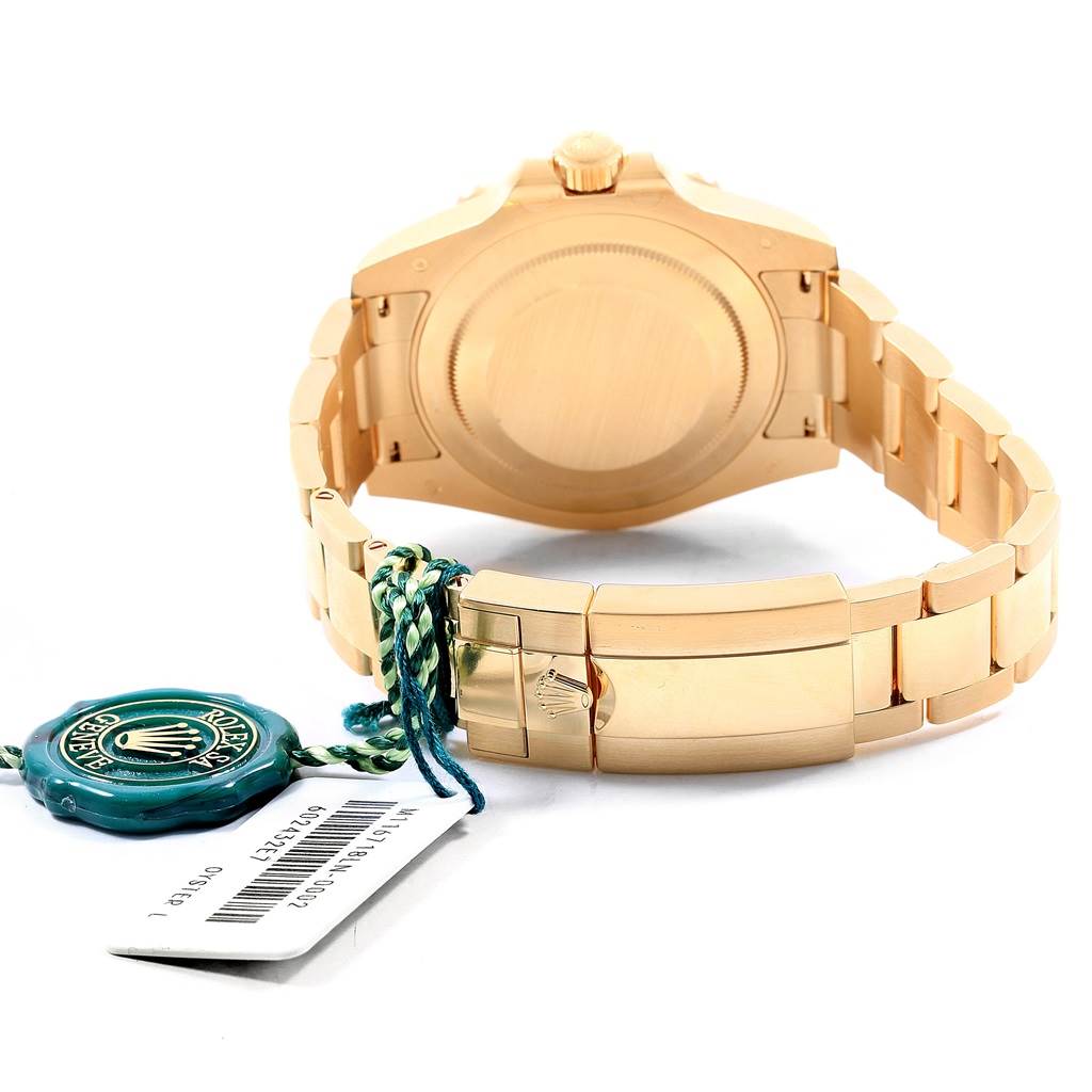 This image shows the back case and bracelet of a Rolex GMT-Master 116718LN Men's Yellow Gold Green Dial 116718LN Men's Yellow Gold Green Dial watch, along with a Rolex identification tag.