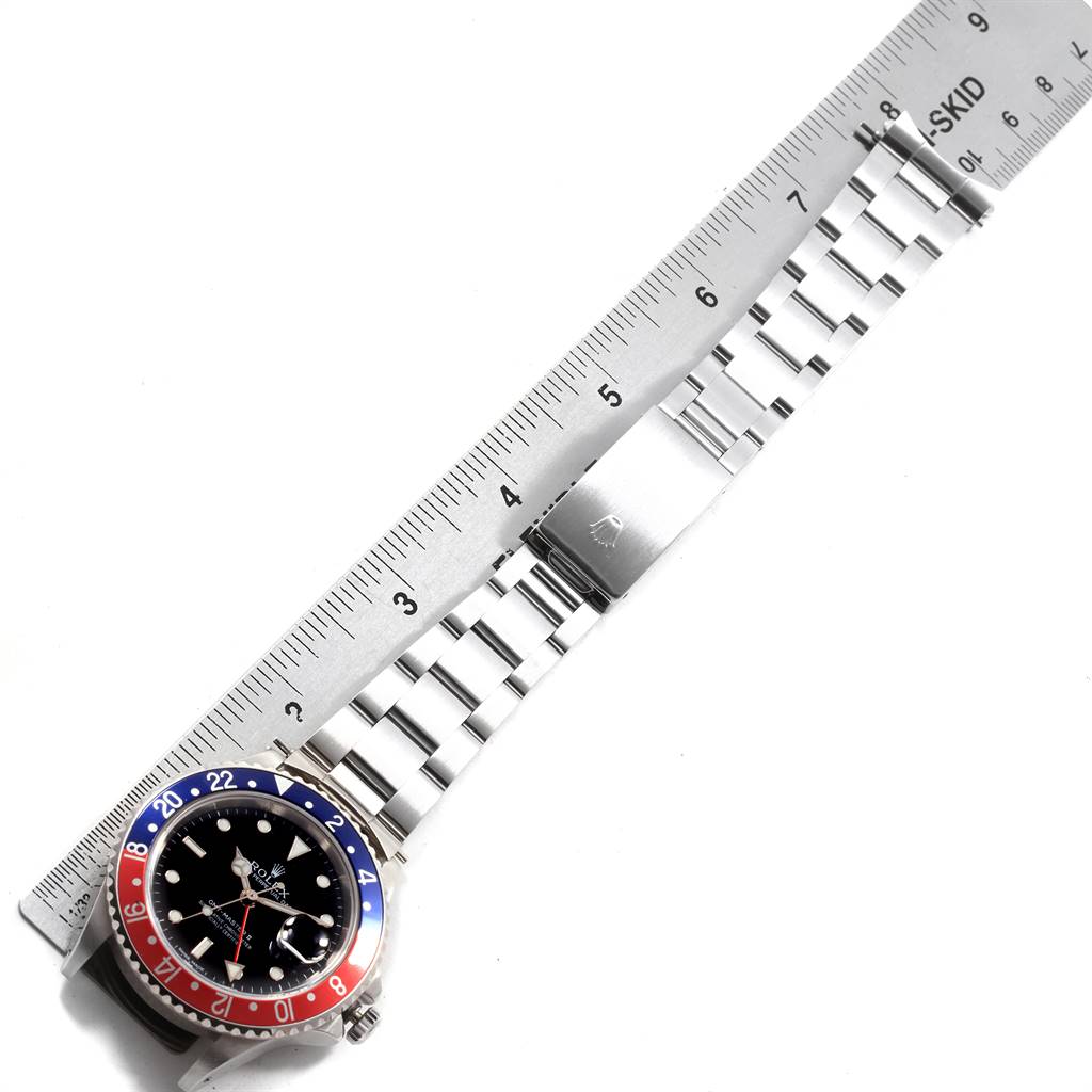 The photo shows a top-down view of a Rolex GMT-Master 16760 Men's Stainless Steel Black Dial 16760 Men's Stainless Steel Black Dial watch, focusing on the bezel, face, and bracelet, alongside a ruler for scale.