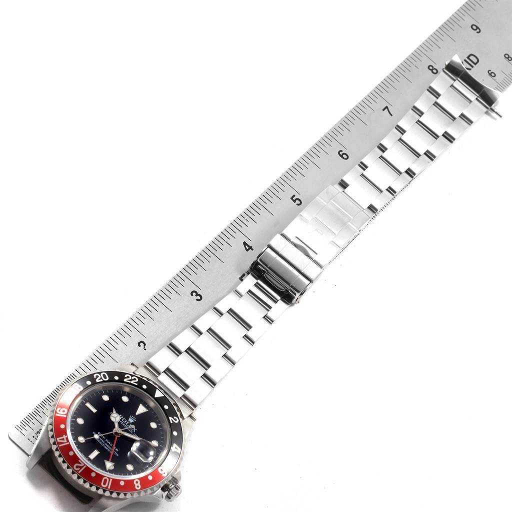 This image shows a Rolex GMT-Master 16700 Men's Stainless Steel Black Dial 16700 Men's Stainless Steel Black Dial watch laid flat with its bracelet extended next to a ruler.