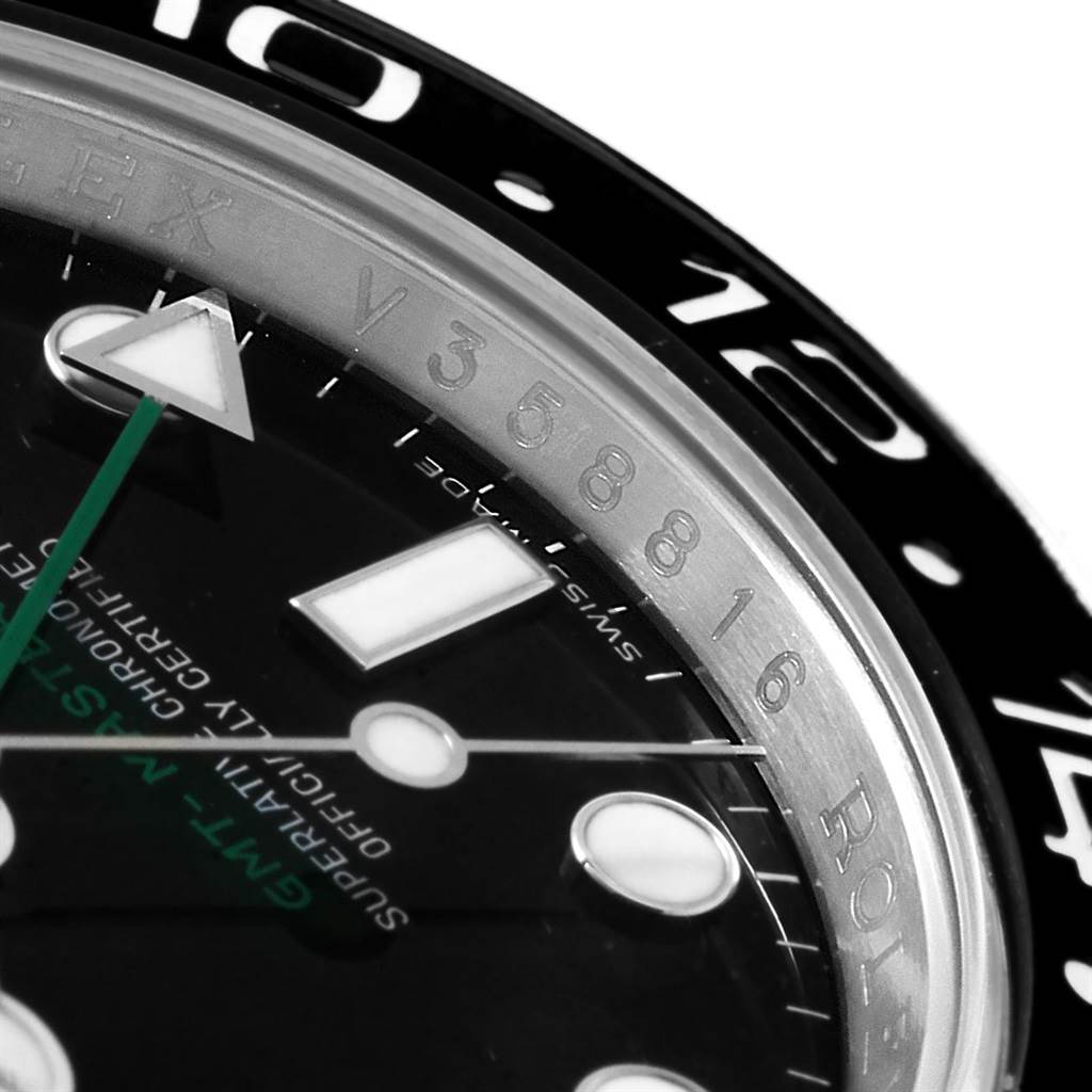 This image shows a close-up of the Rolex GMT-Master 116710 Men's Stainless Steel Black Dial 116710 Men's Stainless Steel Black Dial watch dial, bezel, and rehaut with part of the serial number visible.