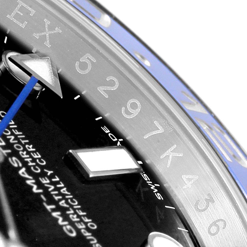 The image shows a close-up of the GMT-Master Rolex watch face, highlighting the dial, part of the bezel, and hour markers.