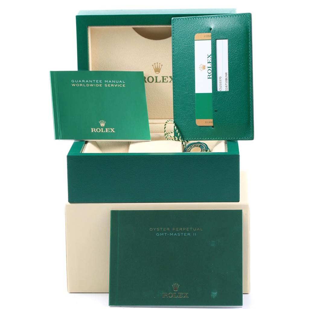 This image shows the packaging and accessories for a Rolex GMT-Master 116710 Men's Stainless Steel Black Dial 116710 Men's Stainless Steel Black Dial watch, including manuals and a warranty card holder.