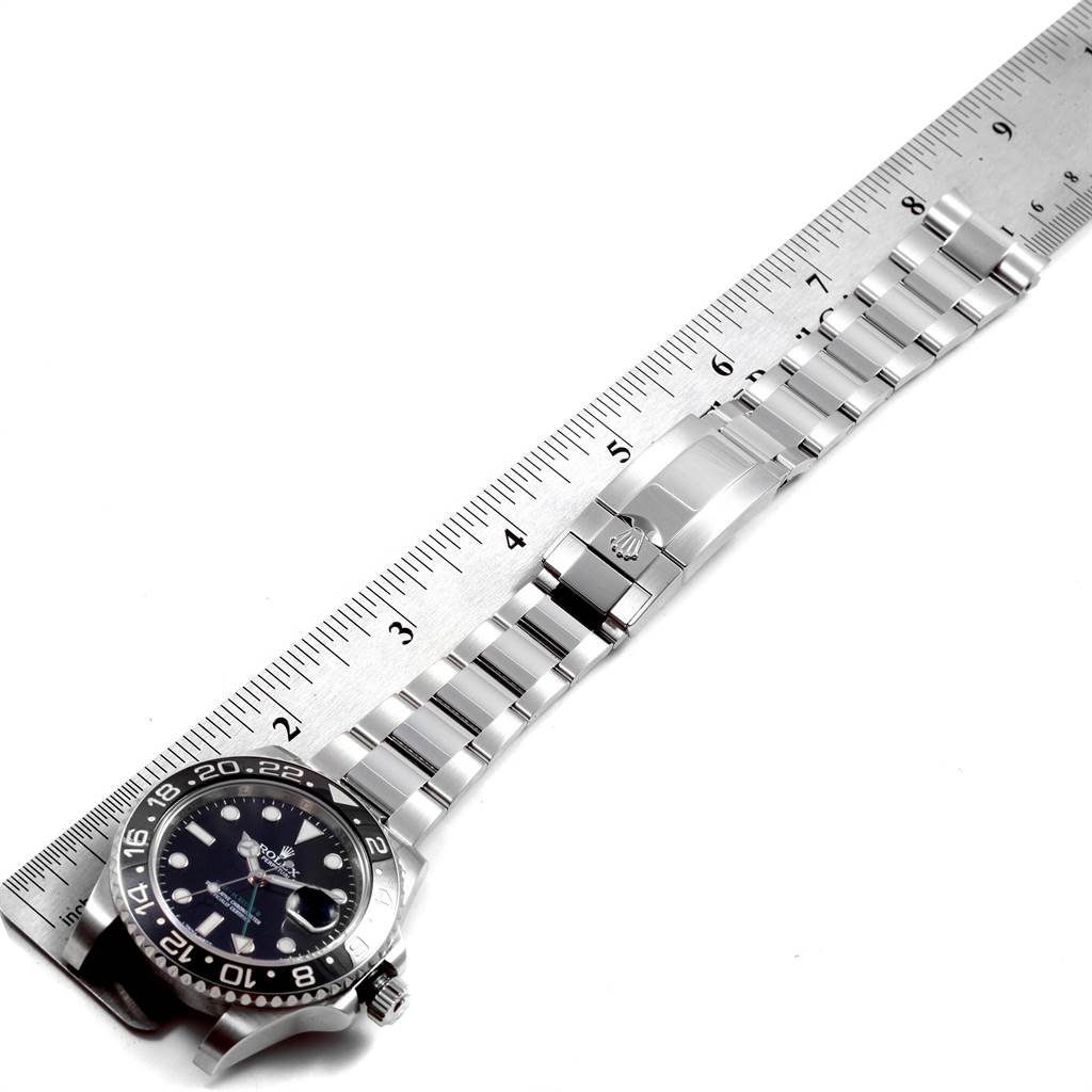 This image shows a Rolex GMT-Master 116710 Men's Stainless Steel Black Dial 116710 Men's Stainless Steel Black Dial watch lying flat next to a ruler, displaying the face, bezel, and bracelet clasp.