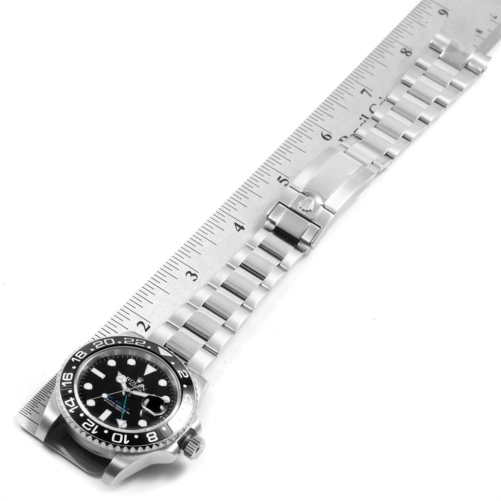 The image shows a Rolex GMT-Master 116710 Men
s Stainless Steel Black Dial 116710 Men
s Stainless Steel Black Dial watch laid flat, with its bracelet and clasp fully extended next to a ruler.