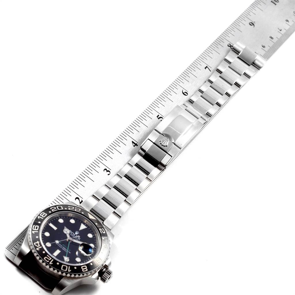 The image shows a top-view angle of a Rolex GMT-Master 116710 Men's Stainless Steel Black Dial 116710 Men's Stainless Steel Black Dial watch with a stainless steel bracelet and bezel, alongside a ruler for scale.