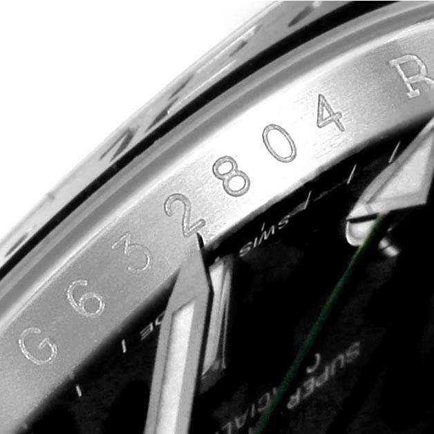 This close-up image of the Rolex GMT-Master 116710 Men's Stainless Steel Black Dial 116710 Men's Stainless Steel Black Dial model showcases the engraved serial number and watch hands.