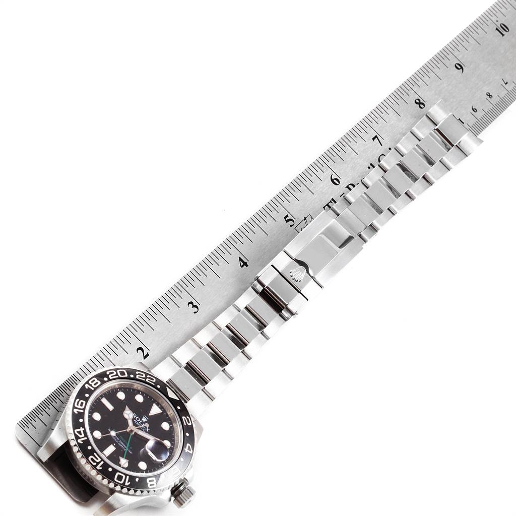 This image shows a Rolex GMT-Master 116710 Men's Stainless Steel Black Dial 116710 Men's Stainless Steel Black Dial watch laid flat next to a ruler, highlighting the watch face and the entire metal bracelet.