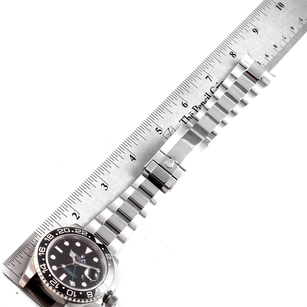 The image shows a Rolex GMT-Master 116710 Men
s Stainless Steel Black Dial 116710 Men
s Stainless Steel Black Dial watch laid flat alongside a ruler, displaying the face and bracelet band.