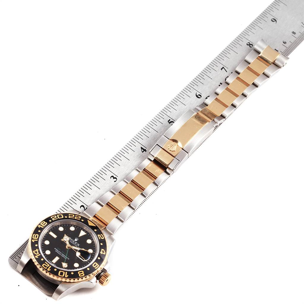 The image shows a Rolex GMT-Master 116713 Men's Stainless Steel Black Dial 116713 Men's Stainless Steel Black Dial watch laying flat to display the entire length of its bracelet and the bezel face, next to a ruler for measurement.