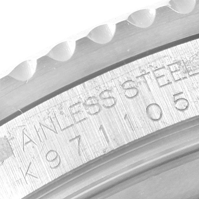 This close-up shot of the Rolex GMT-Master 16710 Men's Stainless Steel Black Dial 16710 Men's Stainless Steel Black Dial watch shows part of the stainless steel bezel and engraved serial number.