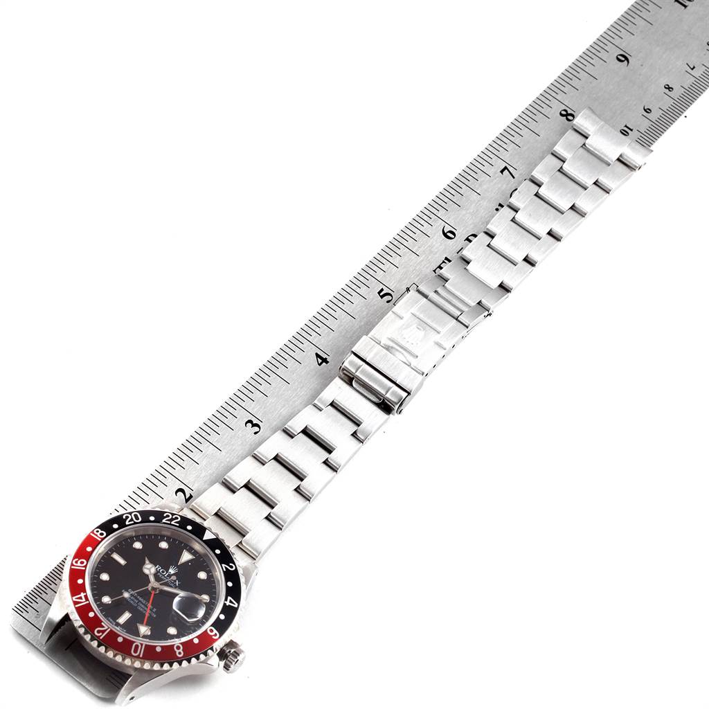 The image shows a Rolex GMT-Master 16710 Men's Stainless Steel Black Dial 16710 Men's Stainless Steel Black Dial watch with its bracelet extended next to a ruler for scale.