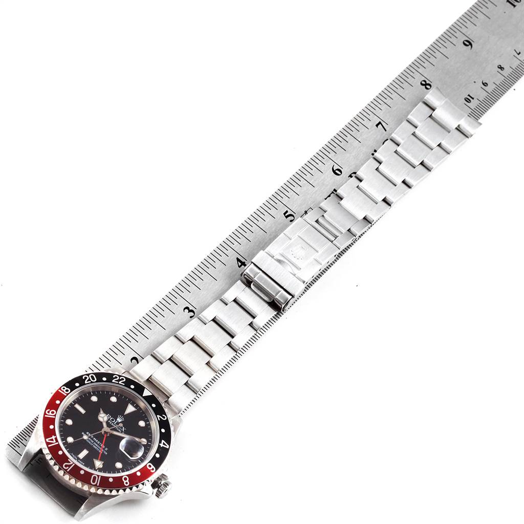 The Rolex GMT-Master 16710 Men
s Stainless Steel Black Dial 16710 Men
s Stainless Steel Black Dial watch is shown from an angled top view, highlighting the bezel, dial, and part of the metal bracelet next to a ruler.