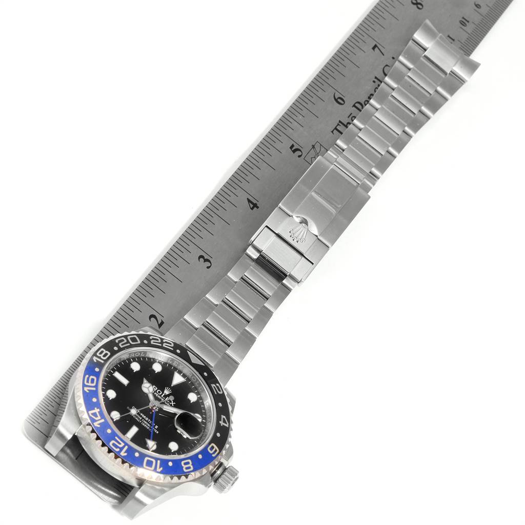 The image shows a Rolex GMT-Master 116710 Men's Stainless Steel Black Dial 116710 Men's Stainless Steel Black Dial watch laid out flat next to a ruler, displaying its face, bezel, and bracelet.