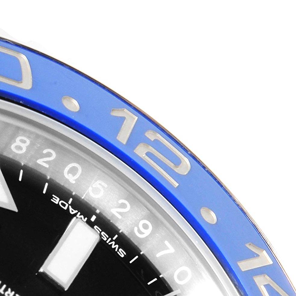 This close-up image of the Rolex GMT-Master 116710 Men's Stainless Steel Black Dial 116710 Men's Stainless Steel Black Dial watch shows a section of the blue bezel and part of the dial, including the "12" marker.