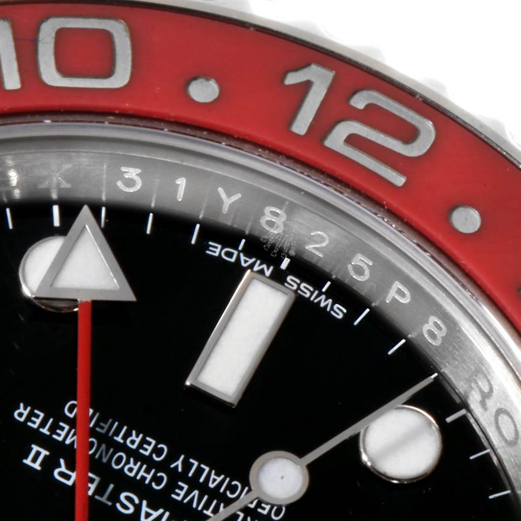 This close-up shot of a Rolex GMT-Master 116719 Men's White Gold Black Dial 116719 Men's White Gold Black Dial shows part of the bezel, dial, and hands, highlighting the 12 o'clock marker and Swiss Made text.