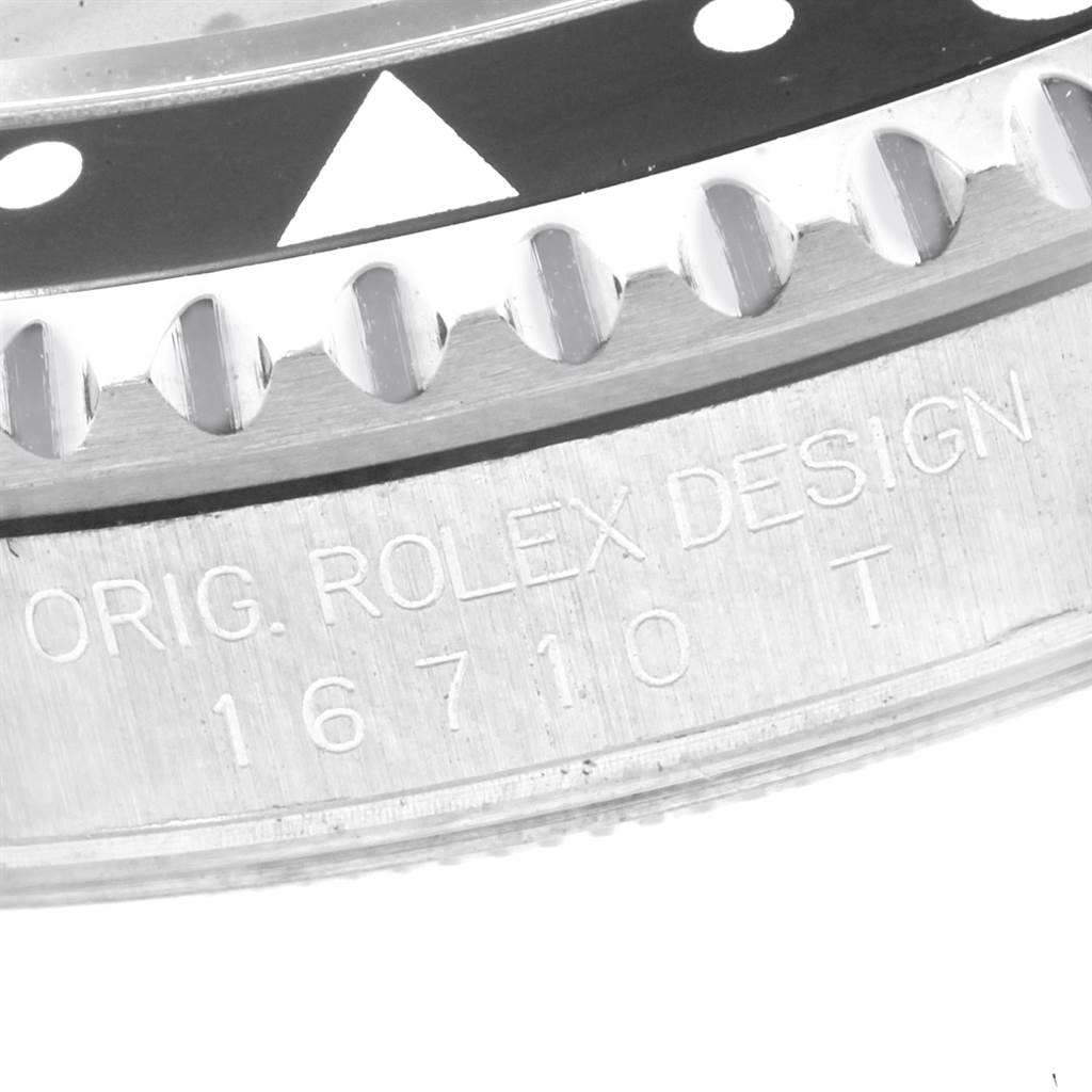 The image shows a close-up angle of the bezel and part of the case of a Rolex GMT-Master 16710 Men
s Stainless Steel Black Dial 16710 Men
s Stainless Steel Black Dial, model 16710, with engraved text.