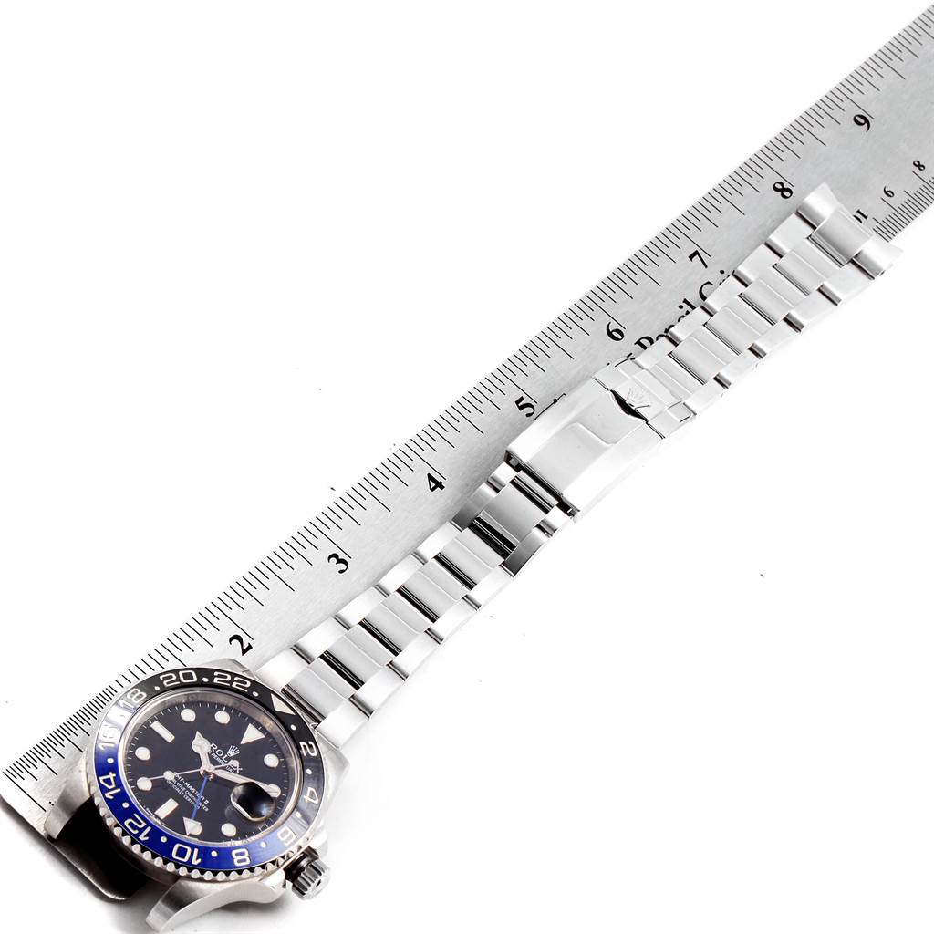 The image shows a top view of a Rolex GMT-Master 116710 Men's Stainless Steel Black Dial 116710 Men's Stainless Steel Black Dial watch, highlighting its face, bezel, and bracelet next to a ruler.