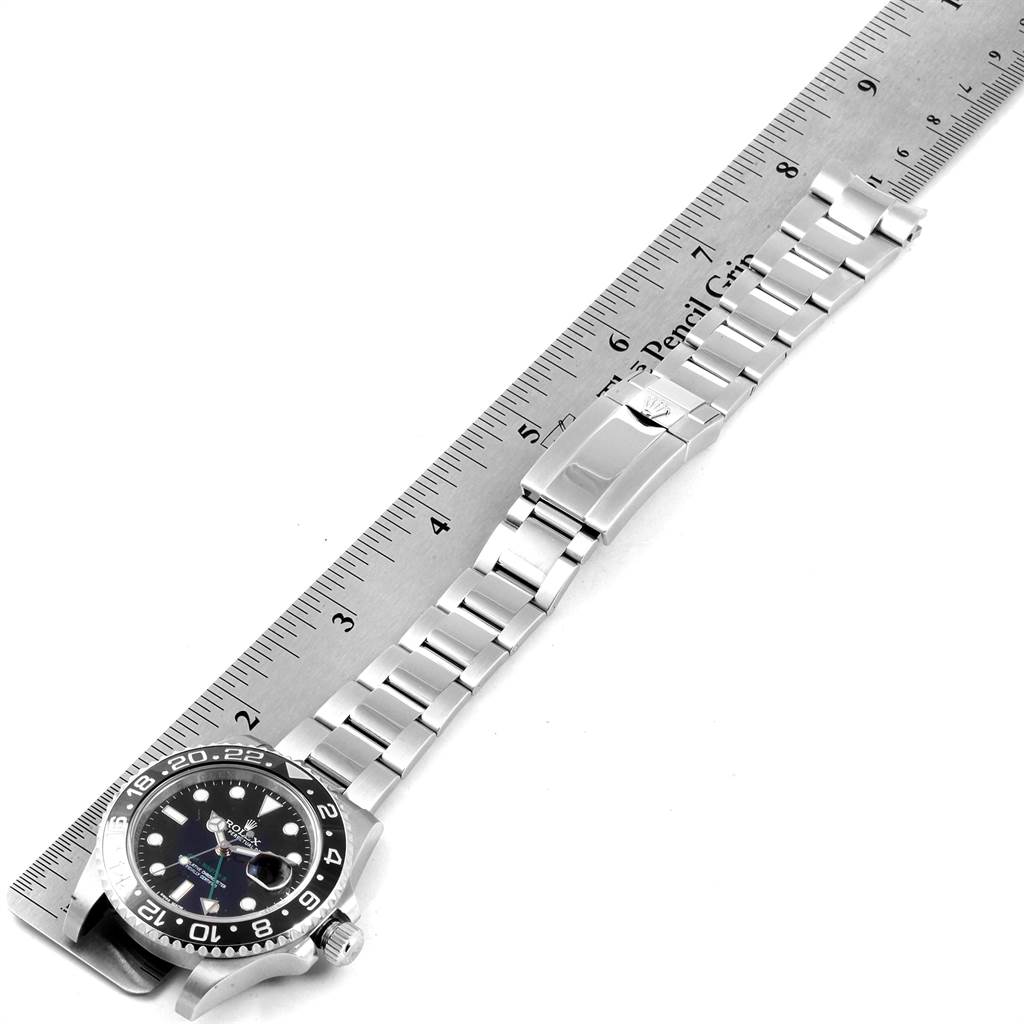 The image shows a top view of a Rolex GMT-Master 116710 Men's Stainless Steel Black Dial 116710 Men's Stainless Steel Black Dial watch laid next to a ruler, displaying its bracelet and clasp.