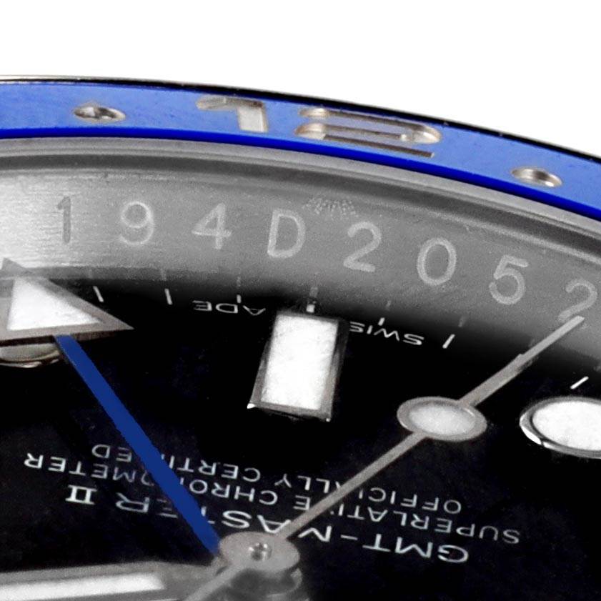 This close-up image of the Rolex GMT-Master 116710 Men's Stainless Steel Black Dial 116710 Men's Stainless Steel Black Dial watch shows the bezel, part of the dial, and the hour and minute hands.