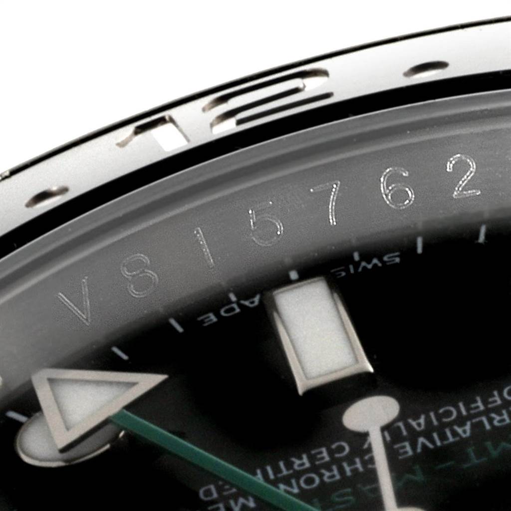 This close-up image of a Rolex GMT-Master 116710 Men's Stainless Steel Black Dial 116710 Men's Stainless Steel Black Dial shows part of the bezel, the engraved serial number, and the hour and minute hands.