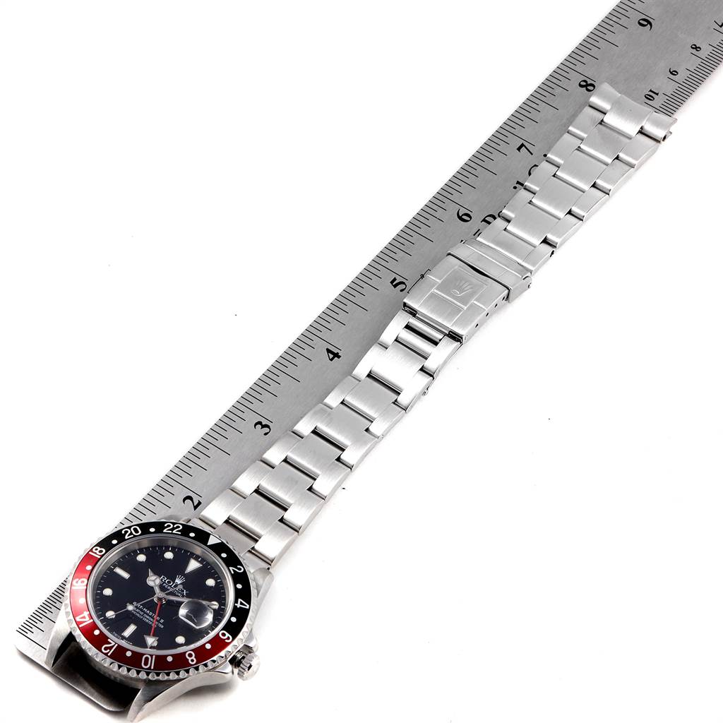 The image shows a Rolex GMT-Master 16710 Men's Stainless Steel Black Dial 16710 Men's Stainless Steel Black Dial watch laid flat next to a ruler, displaying the face, bezel, and full metal bracelet.