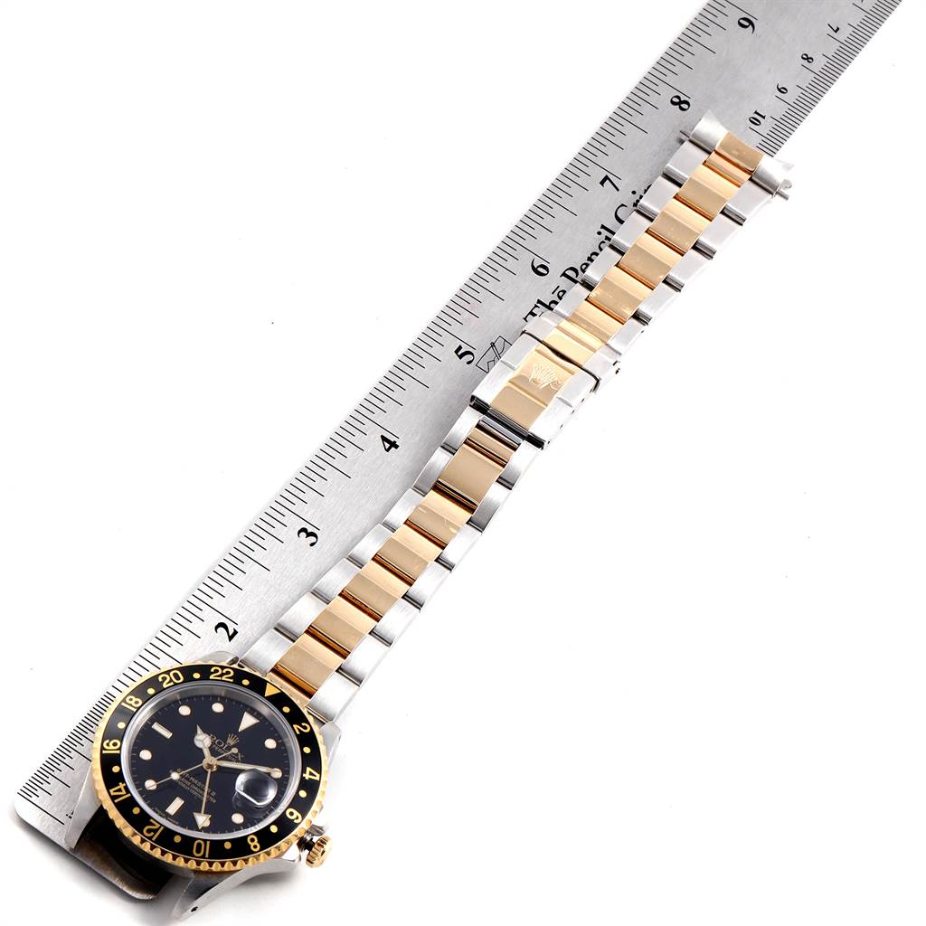 The image shows the Rolex GMT-Master 16713 Men's Stainless Steel Black Dial 16713 Men's Stainless Steel Black Dial watch laid flat, displaying the watch face, bezel, and bracelet next to a ruler.