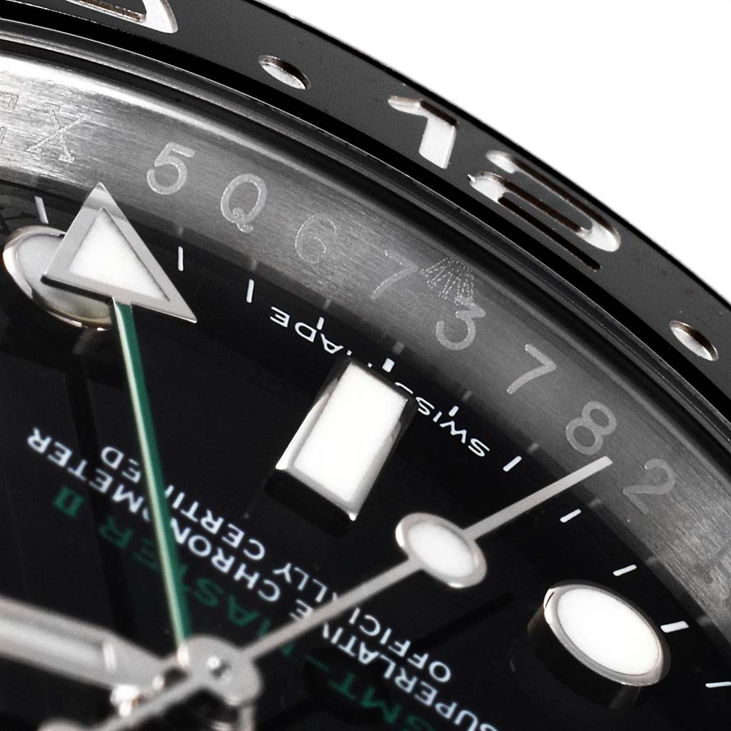 This close-up image of the Rolex GMT-Master 116710 Men's Stainless Steel Black Dial 116710 Men's Stainless Steel Black Dial watch shows part of the bezel, dial, and the tips of the hour and second hands.