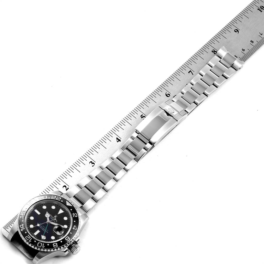 The image shows a top view of a Rolex GMT-Master 116710 Men's Stainless Steel Black Dial 116710 Men's Stainless Steel Black Dial watch with a visible bezel, dial, crown, and bracelet alongside a ruler.