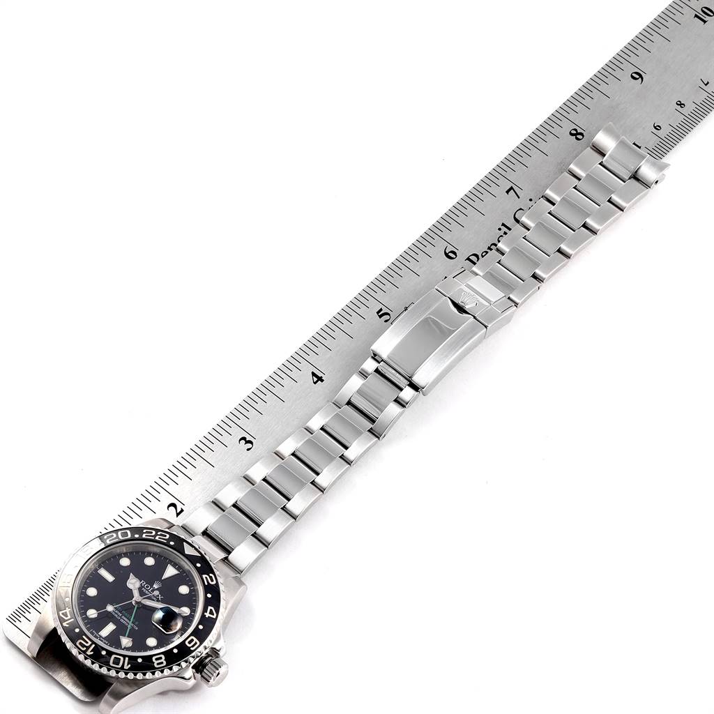 The image shows a top-down view of a Rolex GMT-Master 116710 Men's Stainless Steel Black Dial 116710 Men's Stainless Steel Black Dial watch with the bracelet aligned along a ruler.