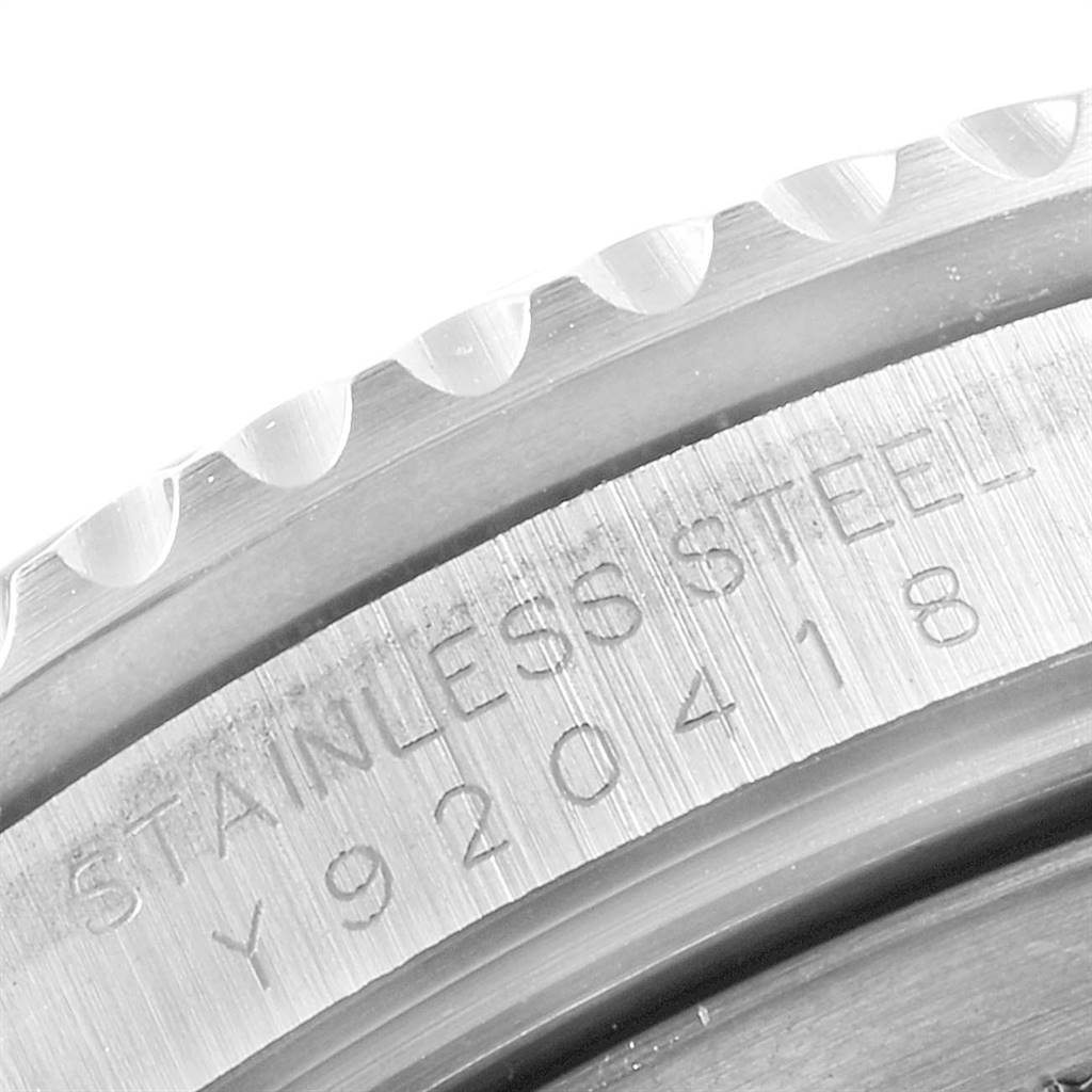 This close-up image of the Rolex GMT-Master 16710 Men's Stainless Steel Black Dial 16710 Men's Stainless Steel Black Dial watch displays part of the stainless steel case's engravings and a section of the bezel.