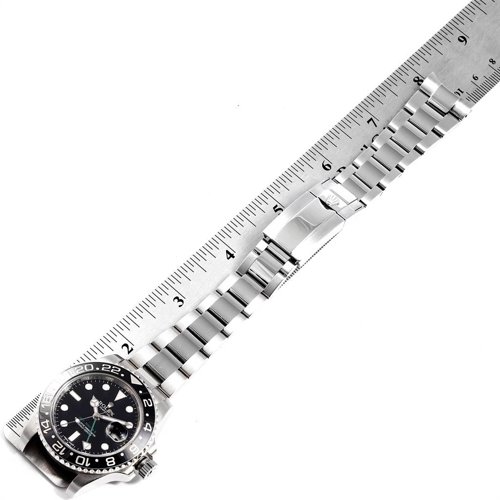 The image shows a top-down view of a Rolex GMT-Master 116710 Men's Stainless Steel Black Dial 116710 Men's Stainless Steel Black Dial watch with its metal bracelet laid along a ruler for measurement.