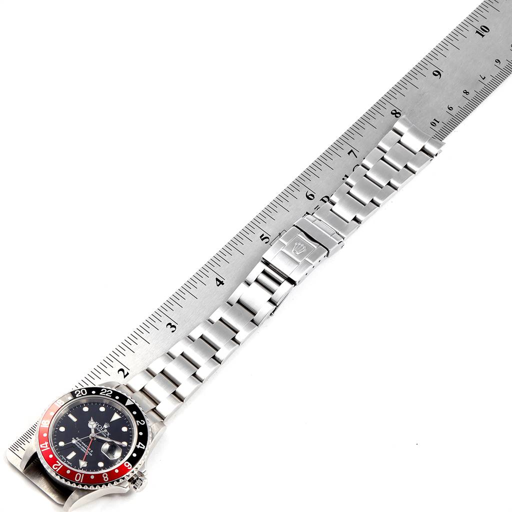 The image shows a top-down view of a Rolex GMT-Master 16710 Men's Stainless Steel Black Dial 16710 Men's Stainless Steel Black Dial watch, focusing on the dial, bezel, and metal bracelet aligned with a ruler for measurement.