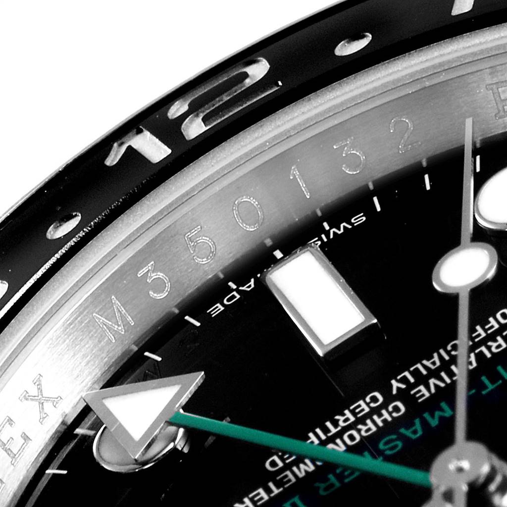 This close-up image of the Rolex GMT-Master 116710 Men's Stainless Steel Black Dial 116710 Men's Stainless Steel Black Dial watch highlights the bezel, part of the dial, and a portion of the minute hand.
