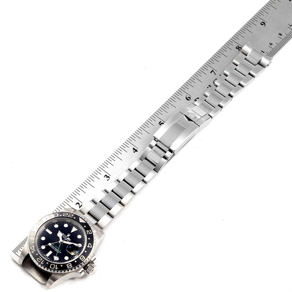 The Rolex GMT-Master 116710 Men's Stainless Steel Black Dial 116710 Men's Stainless Steel Black Dial watch is shown from an overhead angle, highlighting the watch face, bracelet, and clasp with a ruler for scale.