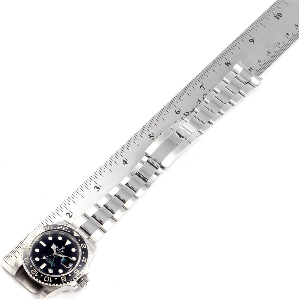 The image shows the Rolex GMT-Master 116710 Men's Stainless Steel Black Dial 116710 Men's Stainless Steel Black Dial watch laid flat next to a ruler, highlighting its metal bracelet and clasp.