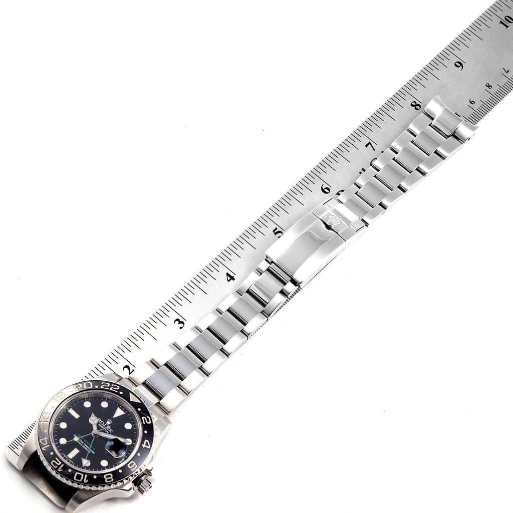 The image shows a top-down view of a Rolex GMT-Master 116710 Men's Stainless Steel Black Dial 116710 Men's Stainless Steel Black Dial watch with its bracelet aligned along a ruler for measurement.