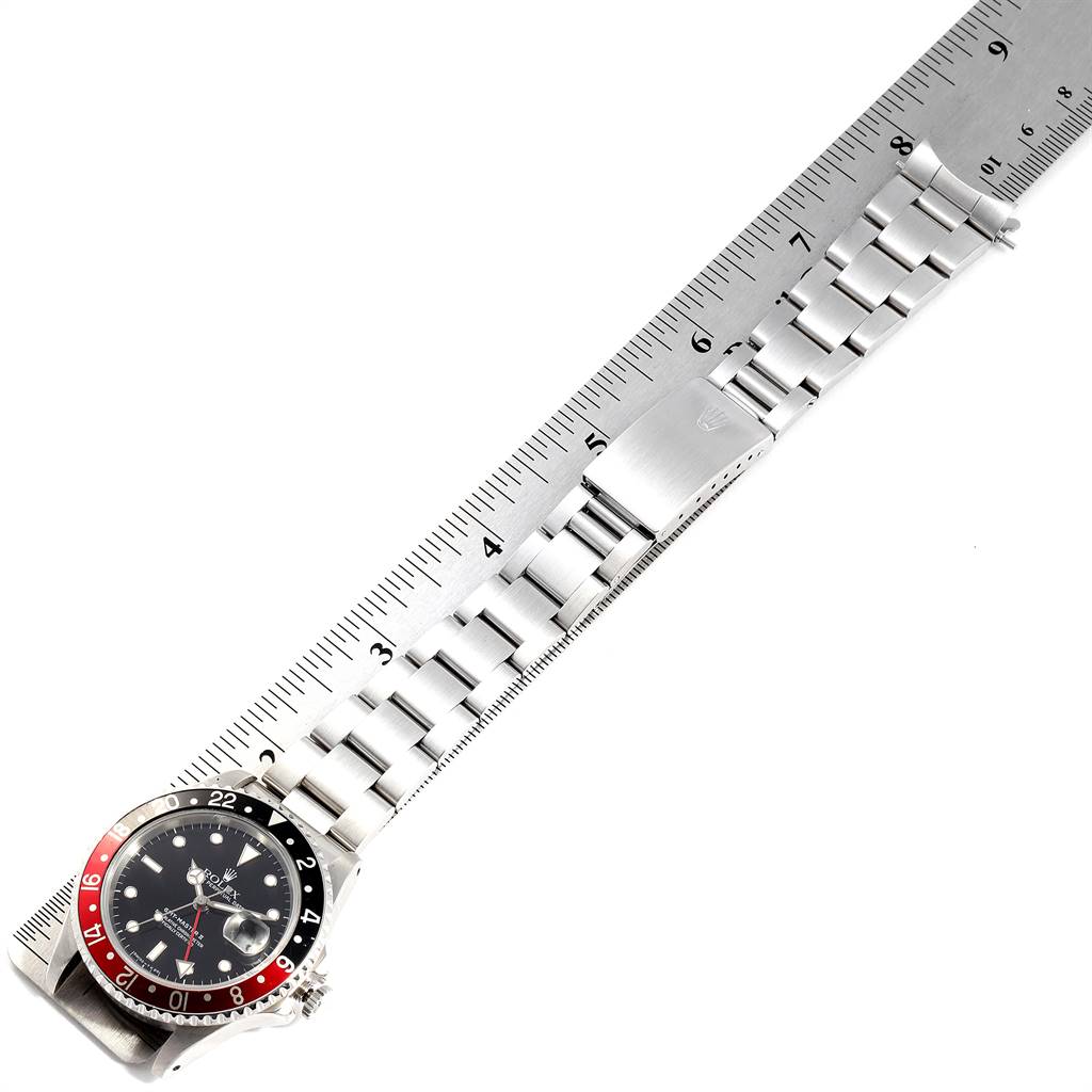 The Rolex GMT-Master 16710 Men's Stainless Steel Black Dial 16710 Men's Stainless Steel Black Dial watch is shown laying flat with the dial, bezel, and bracelet visible alongside a ruler for measurement.