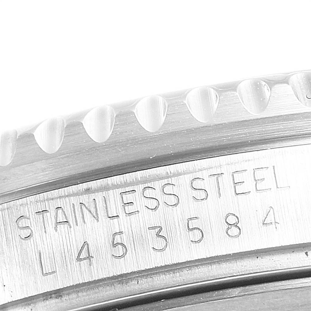 The image shows a close-up of the side of a Rolex GMT-Master 16710 Men's Stainless Steel Black Dial 16710 Men's Stainless Steel Black Dial watch, highlighting the serial number and stainless steel engraving.