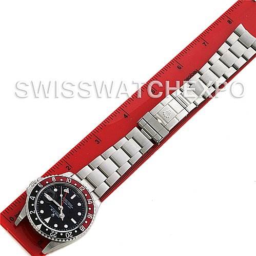 This image shows a top-down view of a Rolex GMT-Master 16710 Men's Stainless Steel Black Dial 16710 Men's Stainless Steel Black Dial watch, featuring the entire watch and bracelet against a red ruler.
