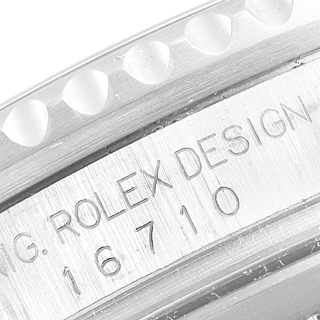 The image shows an angled close-up of the bezel and case of a Rolex GMT-Master 16710 Men
s Stainless Steel Black Dial 16710 Men
s Stainless Steel Black Dial, highlighting the "Rolex Design" engraving.